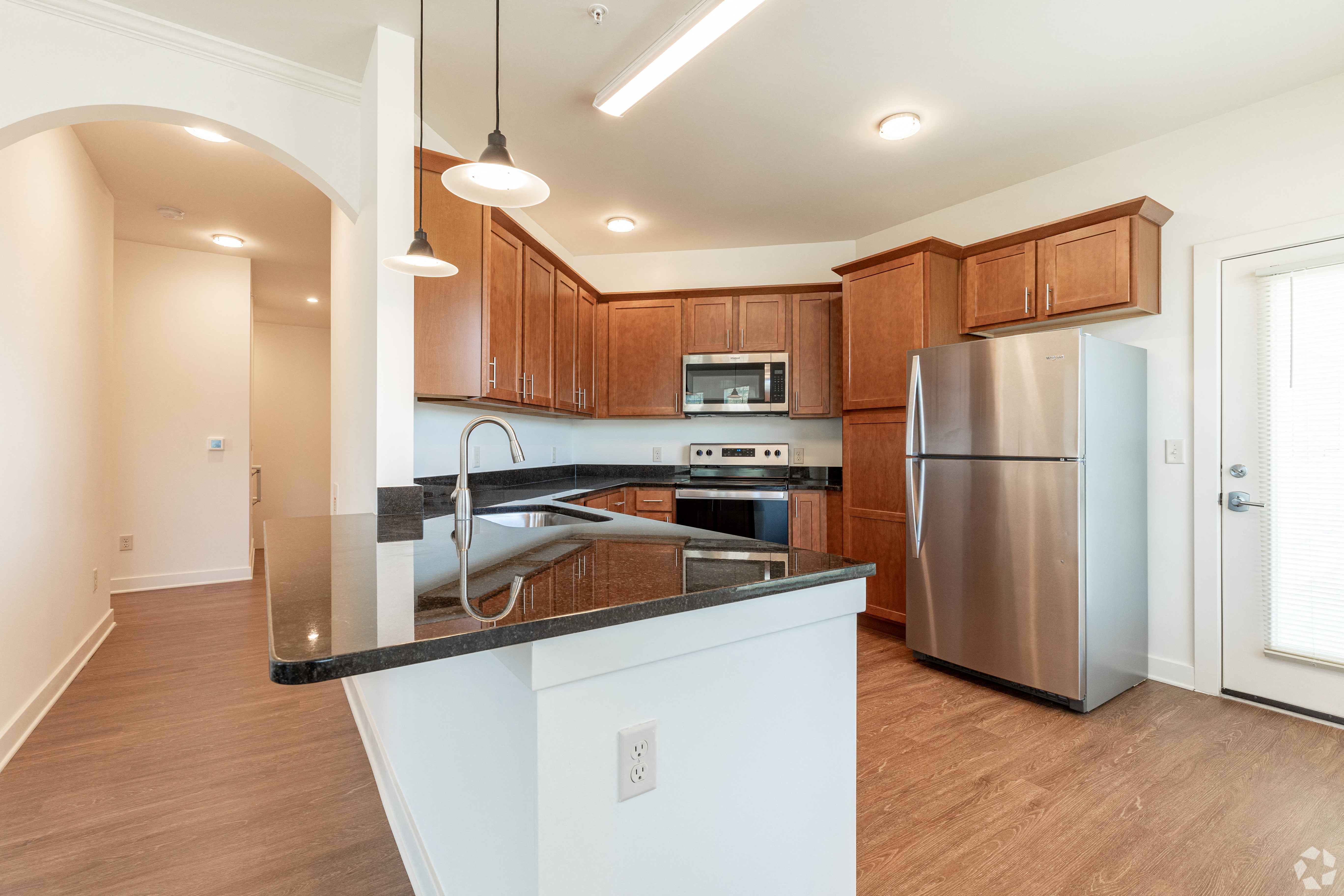 a kitchen with a large island and stainless steel refrigerator